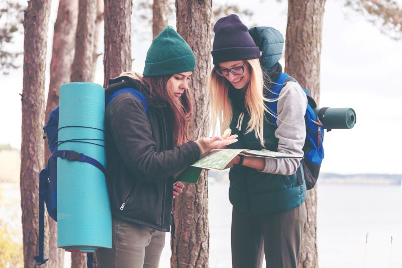 Turystki z mapą i kompasem dwie turystki przeglądające klasyczną mapę