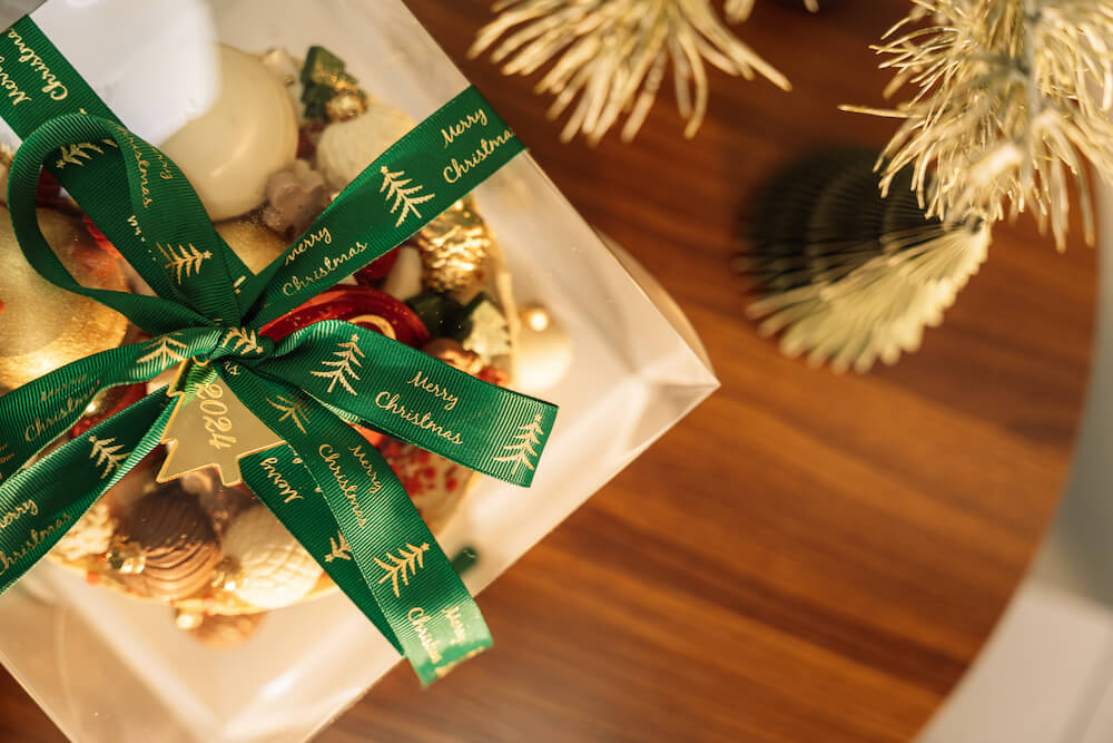 Jak zapakować prezent świąteczny z zieloną wstążką Jak zapakować prezent świąteczny w zieloną wstążkę z napisem