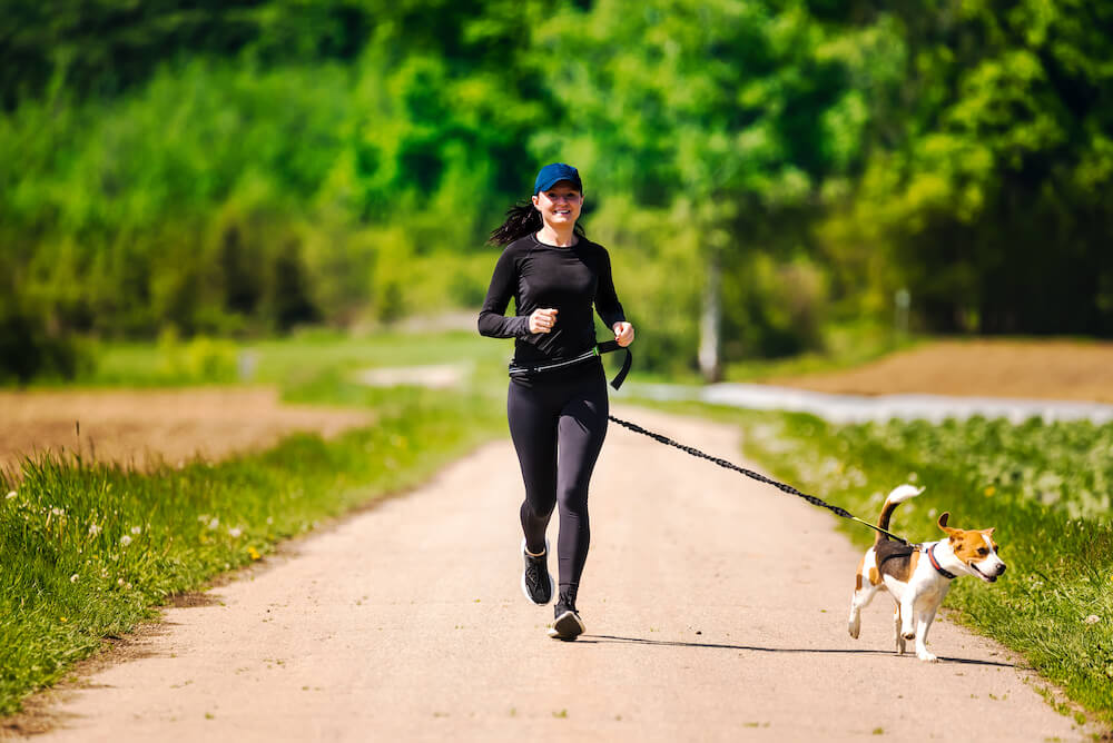 kobieta uprawia jogging z psem