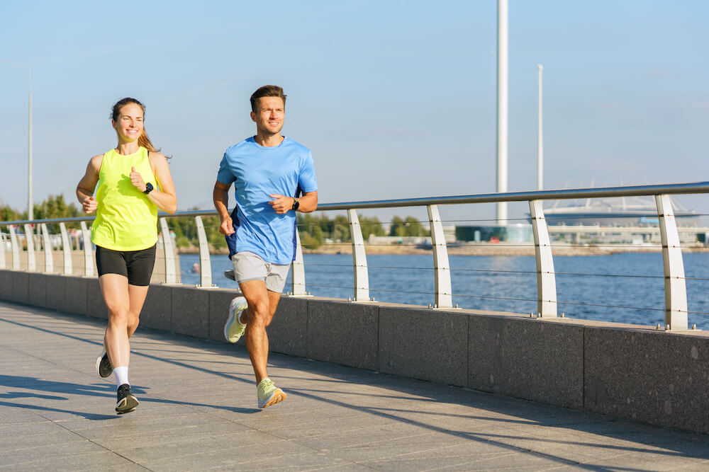 kobieta i mężczyzna biegną nad rzeką