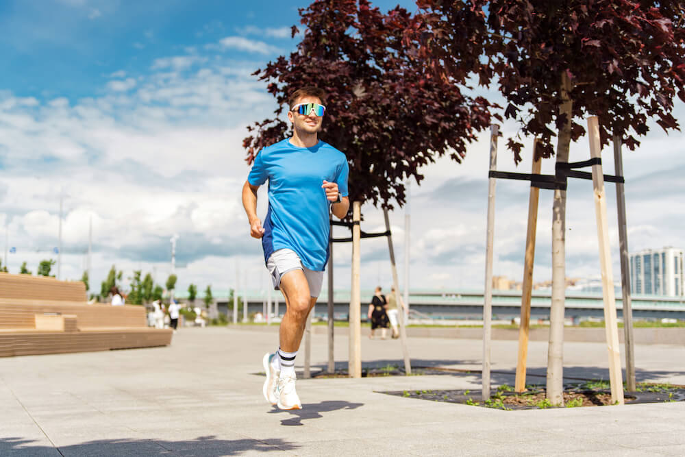 mężczyzna w niebieskiej koszulce uprawiający jogging