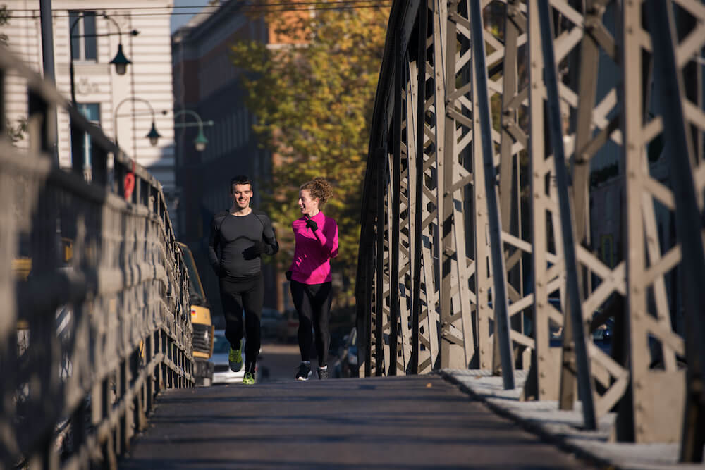 kobieta i mężczyzna biegną przez most