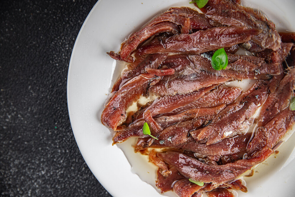 sardele w oleju podane na białym talerzu sardele w oleju na talerzu