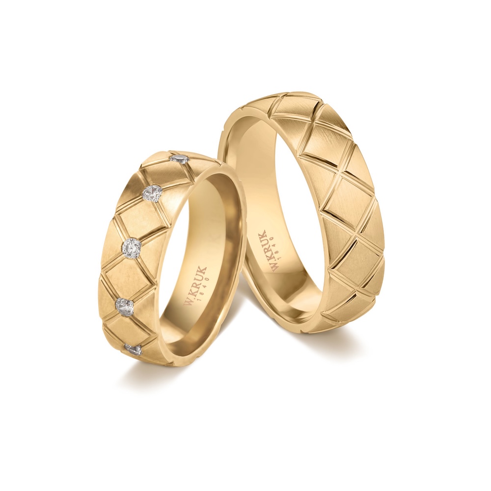 dwie zdobione obrączki ze złota jedna obrączka z diamentami a druga ze wzorem