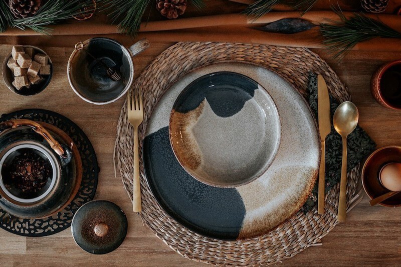 elegancko nakryty stół z ceramiczną zastawą i plecioną podkładką